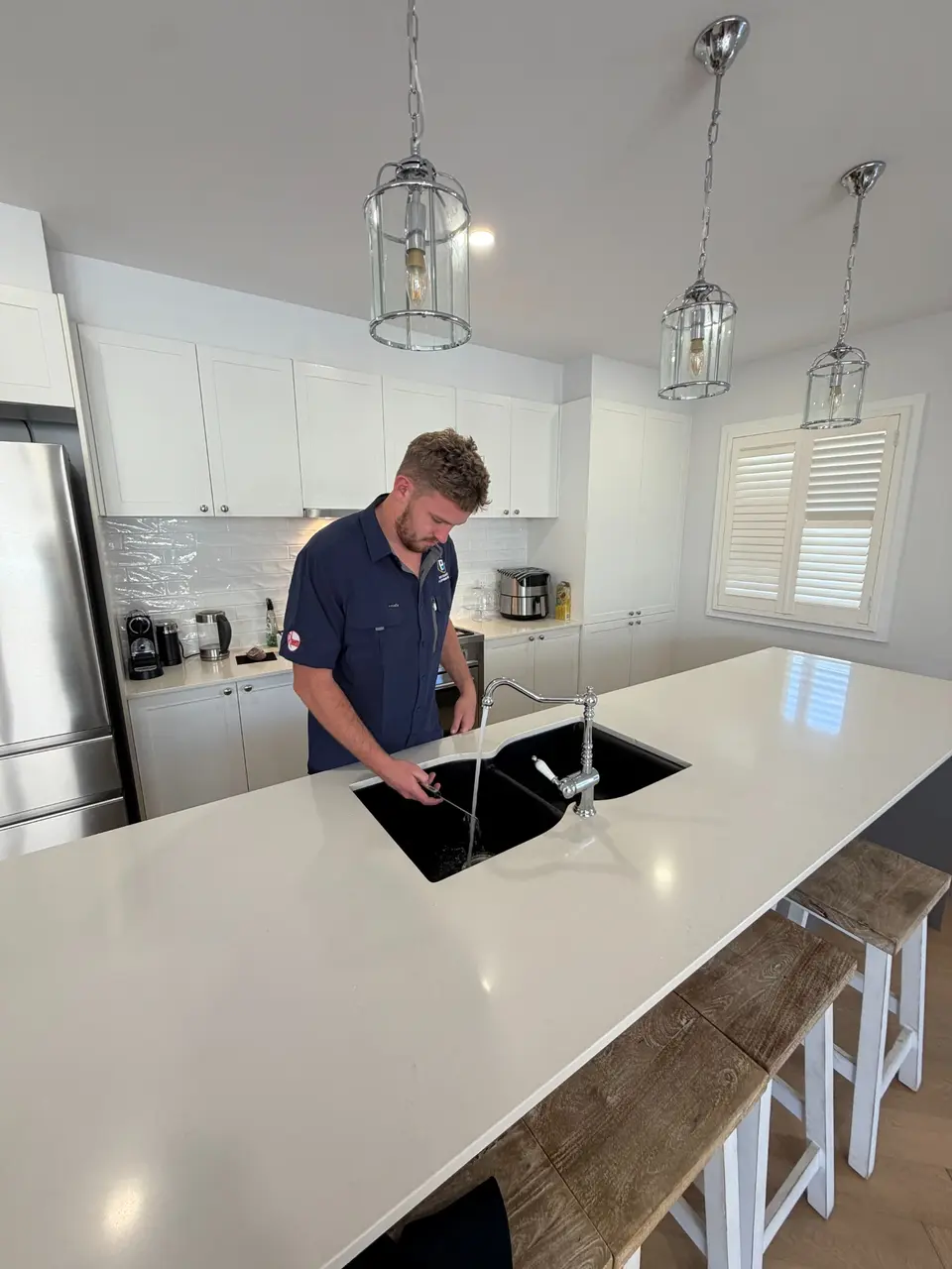 Brisbane plumber inspecting and clearing a blocked kitchen sink