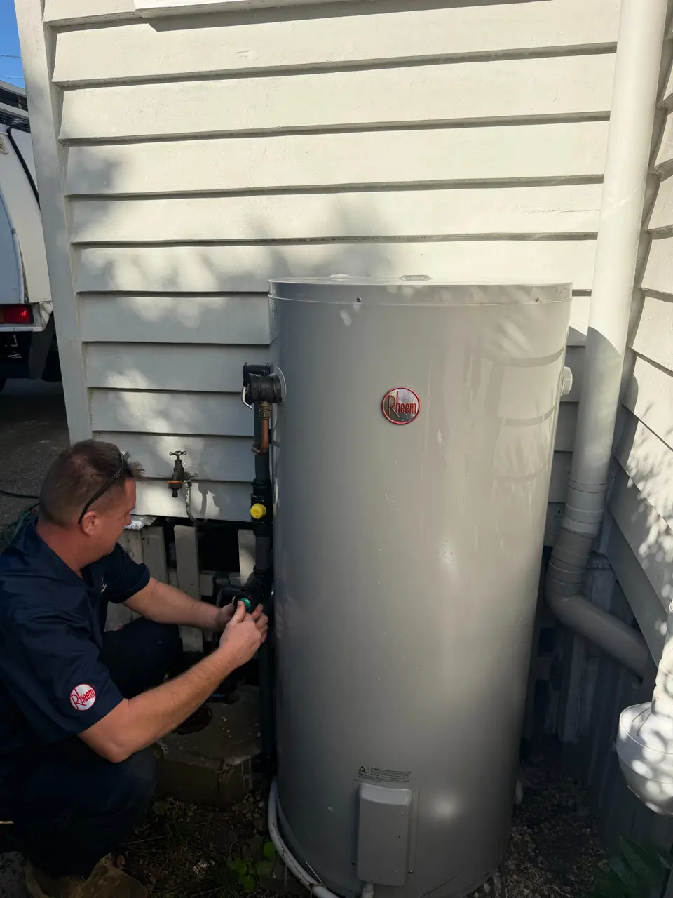 Brisbane City Plumbing and Gas plumber servicing a Rheem electric hot water system in Brisbane
