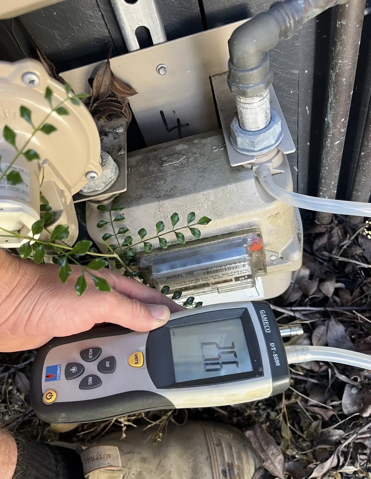 Licensed Brisbane gas fitter carrying out gas pressure testing with a digital manometer
